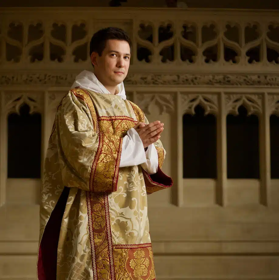 Kapłan w szacie liturgicznej składający ręce do modlitwy